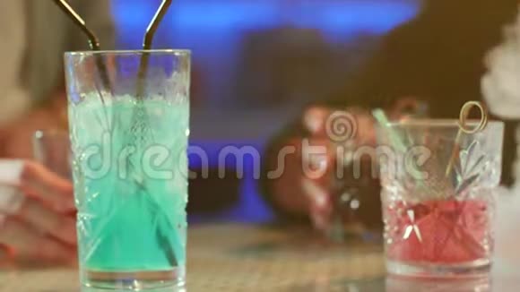 晚上在彩灯背景下配有彩色饮料的近景桌视频的预览图