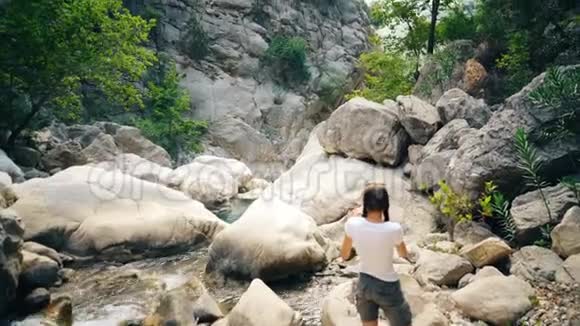 年轻的女游客在旅行时在智能手机摄像头上拍摄美丽的峡谷视频的预览图
