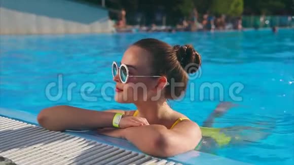 优雅的女人在游泳池里休息喜欢在水里游泳夏天休息视频的预览图