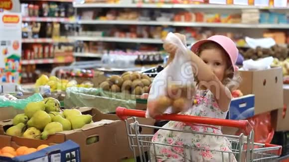商店里的小女孩选水果杂货超市和购物车视频的预览图