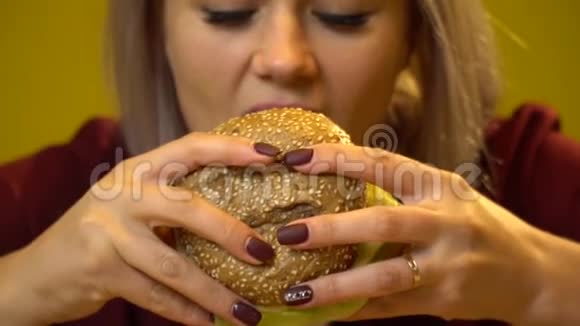 金发女孩吃肉和奶酪汉堡快关门慢动作视频的预览图