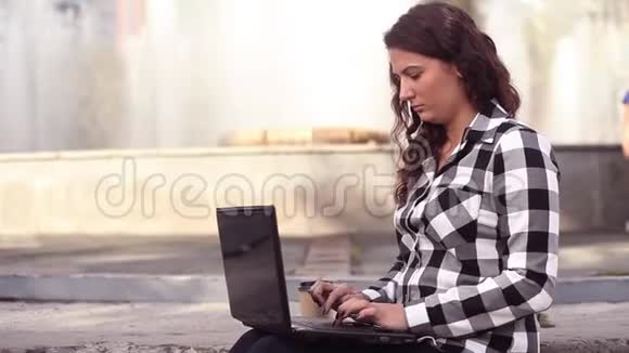 年轻漂亮的快乐商务女性在公园的城市里工作笔记本电脑视频的预览图