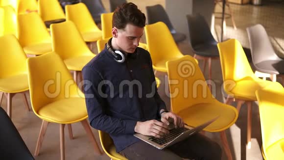 年轻迷人的男性在笔记本电脑上打字在室内工作共同工作空间视频的预览图