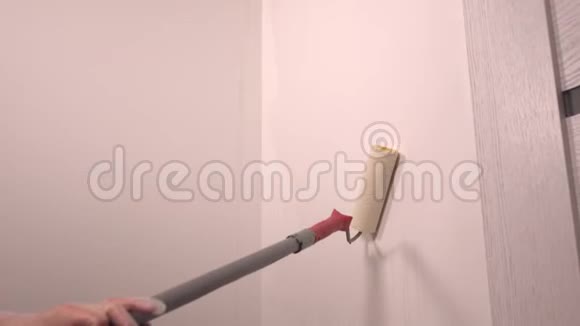 一个人用长滚筒画一堵白色的墙视频的预览图