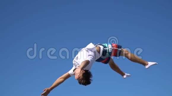一个人飞到空中用手臂和腿在蓝天上挥动动作缓慢视频的预览图
