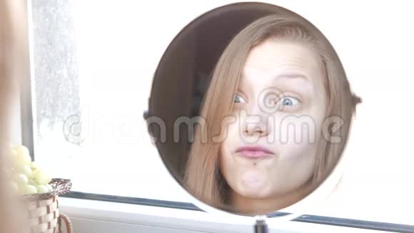 美女模特少女照镜子做滑稽的脸4K视频的预览图