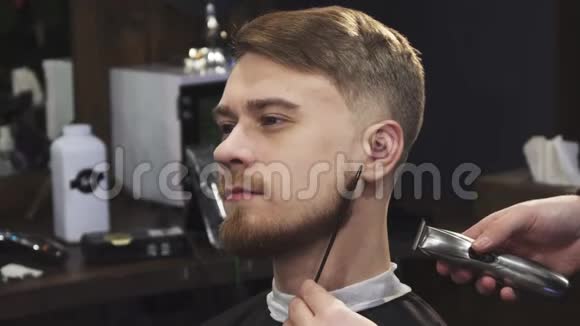 一位年轻的帅哥他的胡子被一位职业理发师修剪过视频的预览图