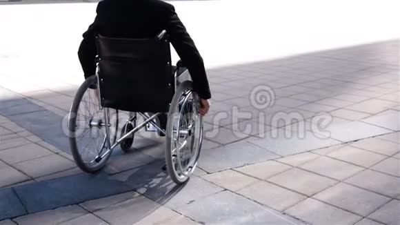 轮椅上的残疾企业家靠近现代商业中心视频的预览图