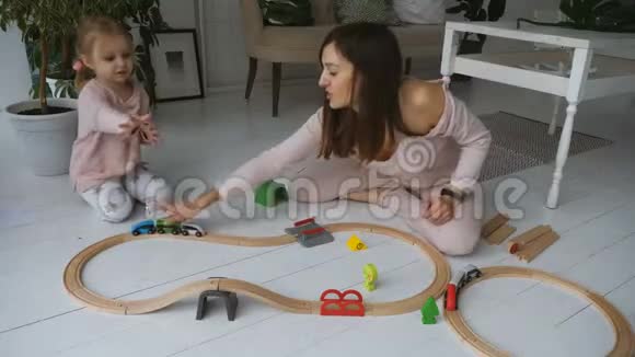 妈妈和她的小女儿玩木铁路视频的预览图