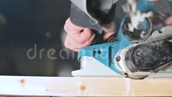大特写木工用电平面切割木板尘埃粒子和锯片的缓慢运动视频的预览图