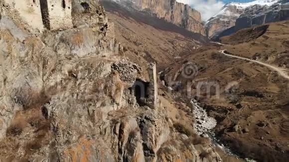 上巴尔卡里亚山上一块岩石上的古塔废墟从空中俯瞰峡谷有一条土路和视频的预览图