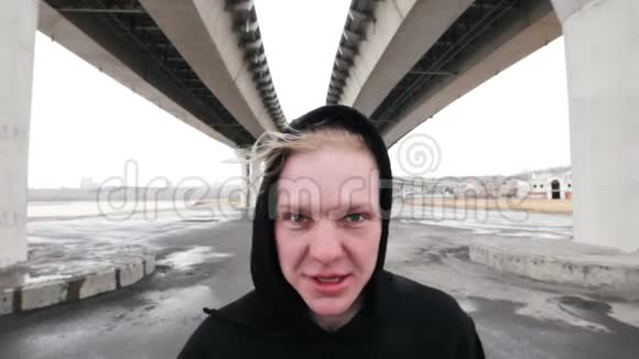 白人年轻人在恶劣的天气下站在桥下视频的预览图