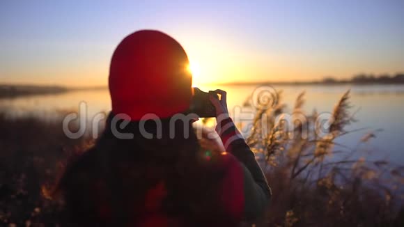 旅游少女旅行者女摄影师拍照少女拍海滩湖照片女人拍照视频的预览图