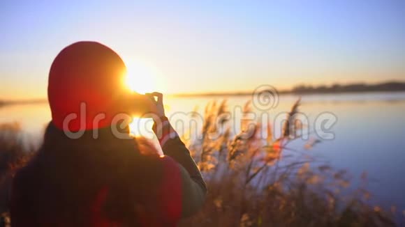 旅游少女旅行者女摄影师拍照少女拍海滩湖照片女人拍照视频的预览图