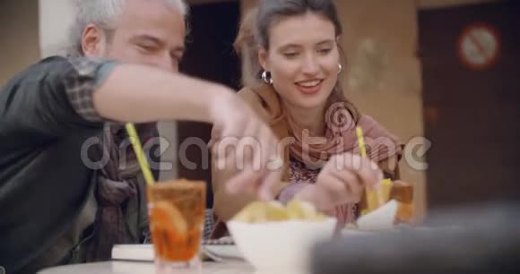女人和男人说在咖啡馆外面喝鸡尾酒开胃酒近距离射击高加索夫妇爱情之旅度假视频的预览图