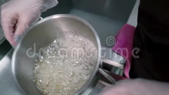 煮沸的糖液正在倒入电动打蛋器中以生产蛋糕视频的预览图