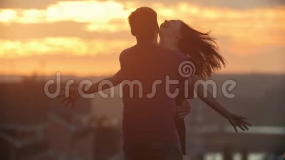 爱的情侣在日落时分慢动作的浪漫视频的预览图