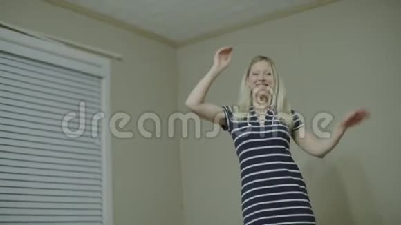 快乐的年轻女子穿着睡衣在厨房跳舞早上听着智能手机上的音乐和家里的咖啡视频的预览图