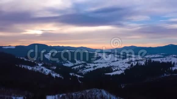 蓝天上的云层过度消散覆盖着雪山和山坡上的针叶林视频的预览图