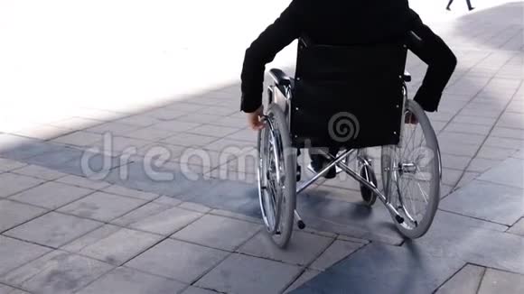 轮椅上的残疾商人靠近现代商业中心视频的预览图