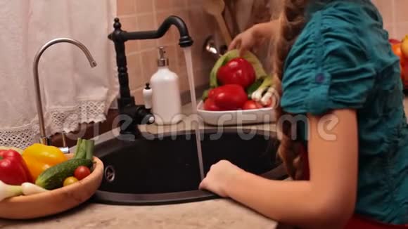 年轻女孩用手冲洗生菜叶视频的预览图