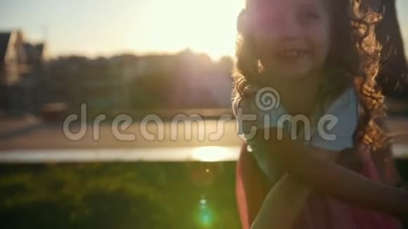 日落时分小女孩在公园里玩耍和摆姿势慢动作视频的预览图