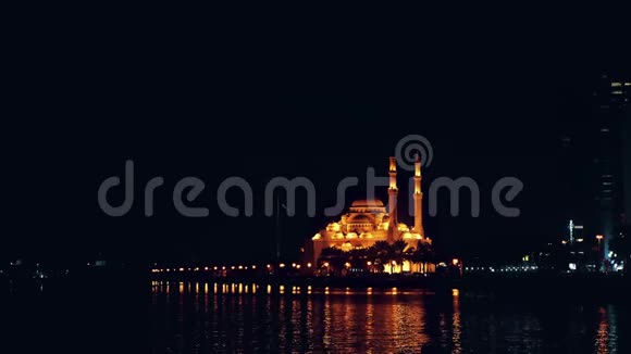夜景照明与金灯清真寺在海滨惊涛拍傍晚海滨大城市的灯光视频的预览图