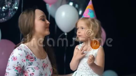 母女的爱拥抱看镜头在节日里妈妈和一个小女孩接吻视频的预览图