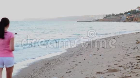在海边沙滩上慢跑的女孩视频的预览图
