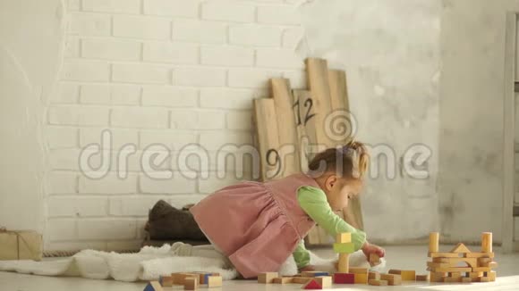 一个漂亮的婴儿在地板上玩木方块教育玩具学前教育幼儿园视频的预览图
