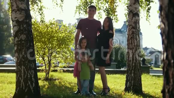 夏天傍晚公园里的一个完整的家庭画像爸爸妈妈女儿和小男孩挥舞着手视频的预览图