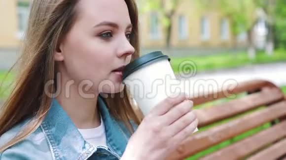 饮料和人的概念快乐的年轻女人或十几岁的女孩喝咖啡从纸杯坐在城市街道上视频的预览图