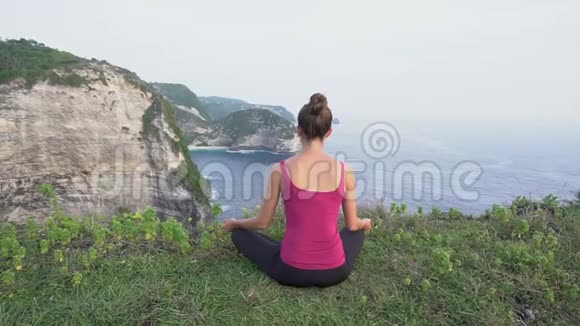冥想中的女性做瑜伽的女人莲花的姿势后景视频的预览图