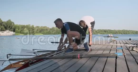 年轻的新手运动员带着双皮划艇青少年们把船放下水视频的预览图
