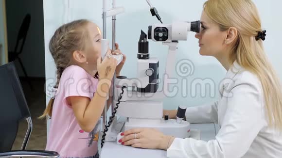 验光师在眼科诊所检查小女孩的视力视频的预览图