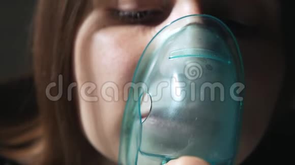 使用雾化器和吸入器进行治疗年轻女子用口罩吸入吸入器视频的预览图