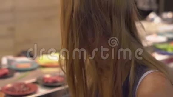 一个亚洲咖啡馆的年轻女子用火锅做饭食物放在小盘子上的传送带上食物传送带视频的预览图