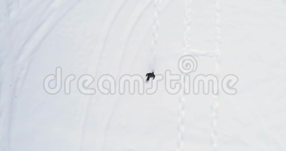 在冬季在白色白雪覆盖的田野上用雪鞋行走的人的头顶俯视欧洲阿尔卑斯山户外视频的预览图