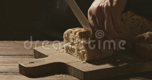 面包师在切割板上用脆皮切一块面包视频的预览图
