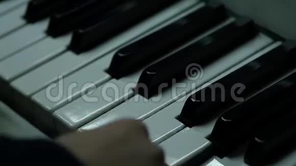 在特写镜头中手拿钢琴钥匙孩子们学习弹钢琴慢动作视频的预览图