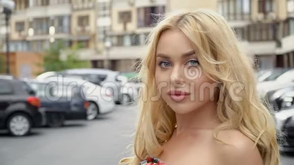 一个金发碧眼的金发碧眼的人在停车场的背景上的肖像视频的预览图