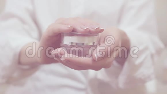 特写镜头温柔的女人手握并打开玻璃罐的皮肤霜漂亮的手优雅的法式视频的预览图