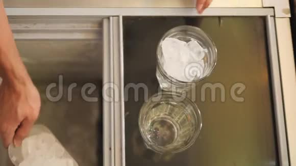 咖啡师把冰杯放进玻璃里开始准备淡夏鸡尾酒4K慢动作视频的预览图