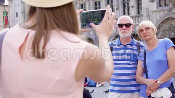 她的女儿在比利时布鲁塞尔中央广场的度假旅行中为她的父母拍照视频的预览图
