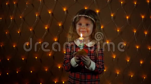 小女孩在节日蛋糕上吹蜡烛视频的预览图