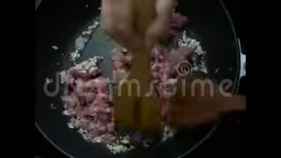 将煎好的咸蛋与猪肉辣椒和大蒜拌入黑色聚四氟乙烯诱导锅中烹饪视频的预览图