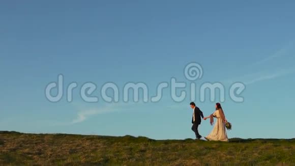 阳光明媚的一天一对夫妇在山上散步视频的预览图