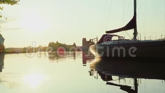 带游艇和特拉凯城堡的湖面日落视频的预览图