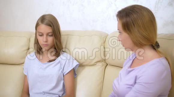 家庭支持和信任的概念妈妈拥抱并安慰坐在客厅沙发上的十几岁的女儿视频的预览图