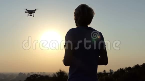 年轻的摄影师在斯洛文尼亚的日落时操作一架飞行的四翼飞机视频的预览图